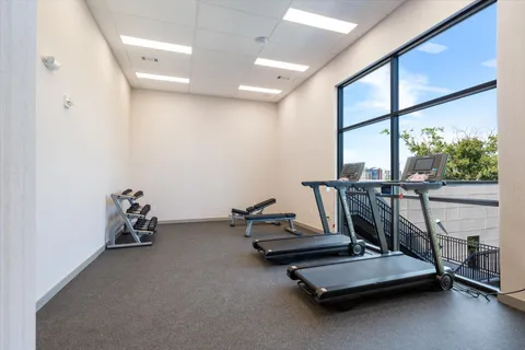 a room with gym equipment and large window