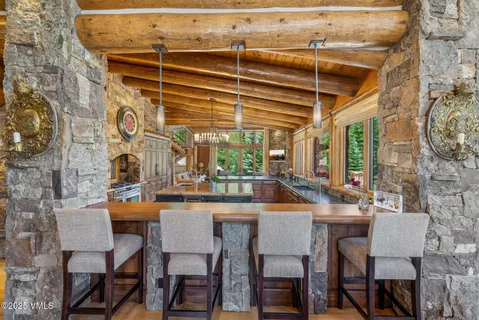 a living room with furniture a fireplace and floor to ceiling windows