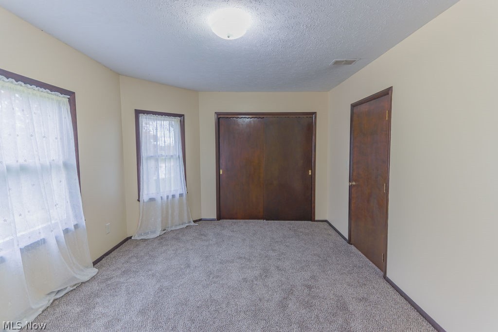 51883 Telegraph Road Amherst, OH 44001 - Photo 9 of 49 Unfurnished bedroom with a textured ceiling and light carpet