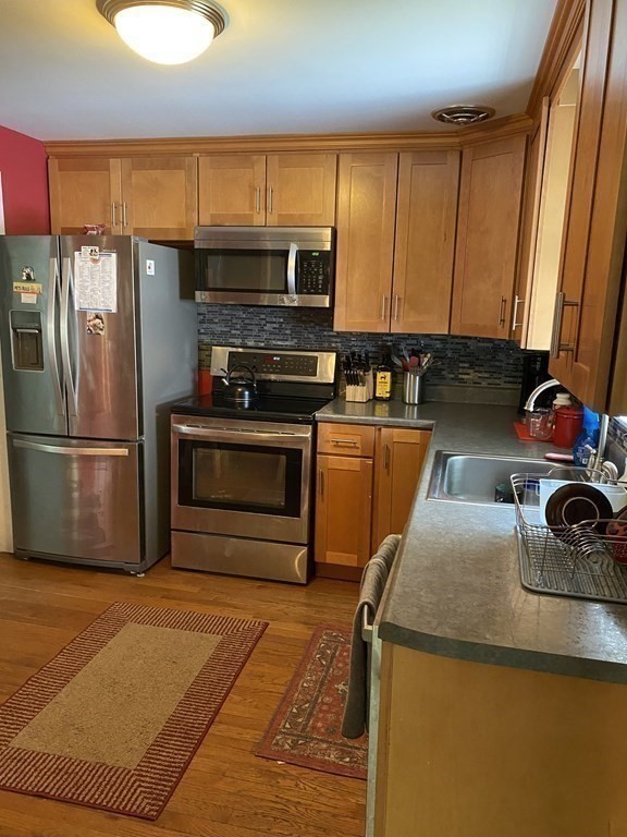 68 Thayer Circle Randolph, MA 02368 - Photo 10 of 25 a kitchen with a sink a stove and a refrigerator