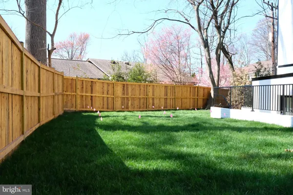 a view of backyard with wooden fence