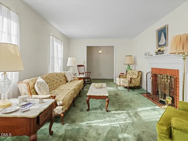 a living room with fireplace furniture and a window
