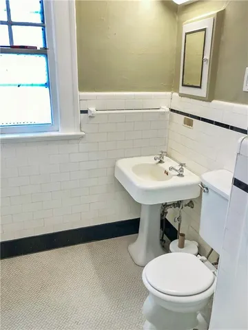 a bathroom with a sink a toilet and mirror
