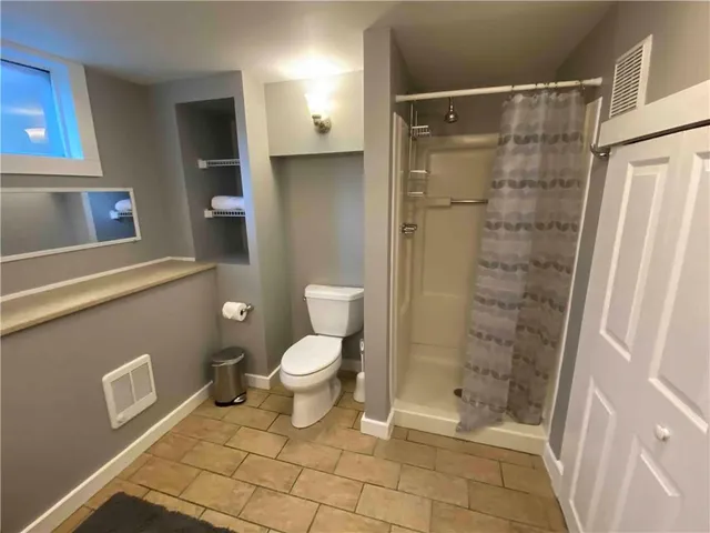 a bathroom with a toilet and a shower