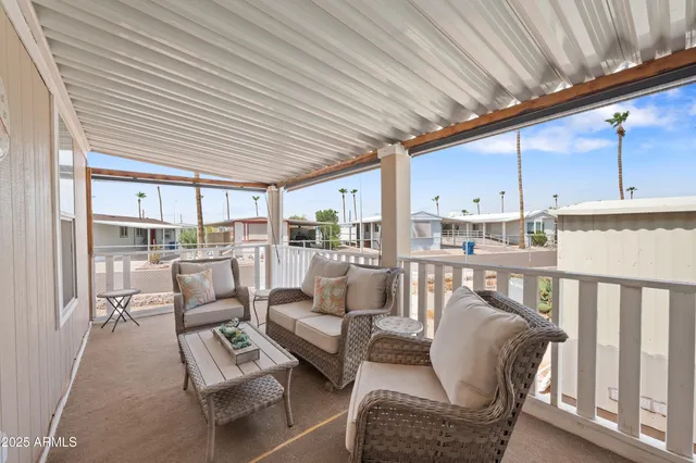 a living room with furniture kitchen view and a large window