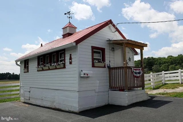 a view of an empty room with wooden floor and closet