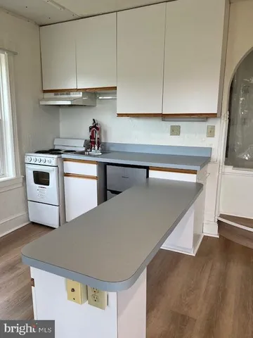 a kitchen with a refrigerator and a stove top oven