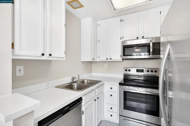 a kitchen with stainless steel appliances a stove a sink and a refrigerator