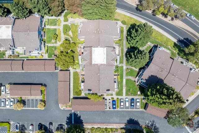 an aerial view of residential houses with outdoor space and trees