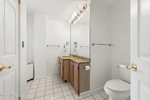 a bathroom with a granite countertop window a toilet and a shower