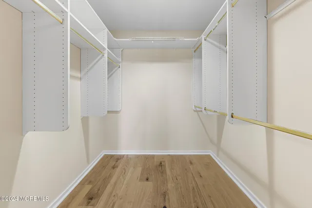 a view of walk in closet with wooden floor