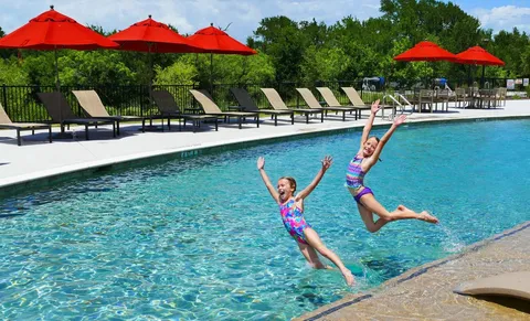 a kitchen with stainless steel appliances kitchen island granite countertop a table chairs and a refrigerator
