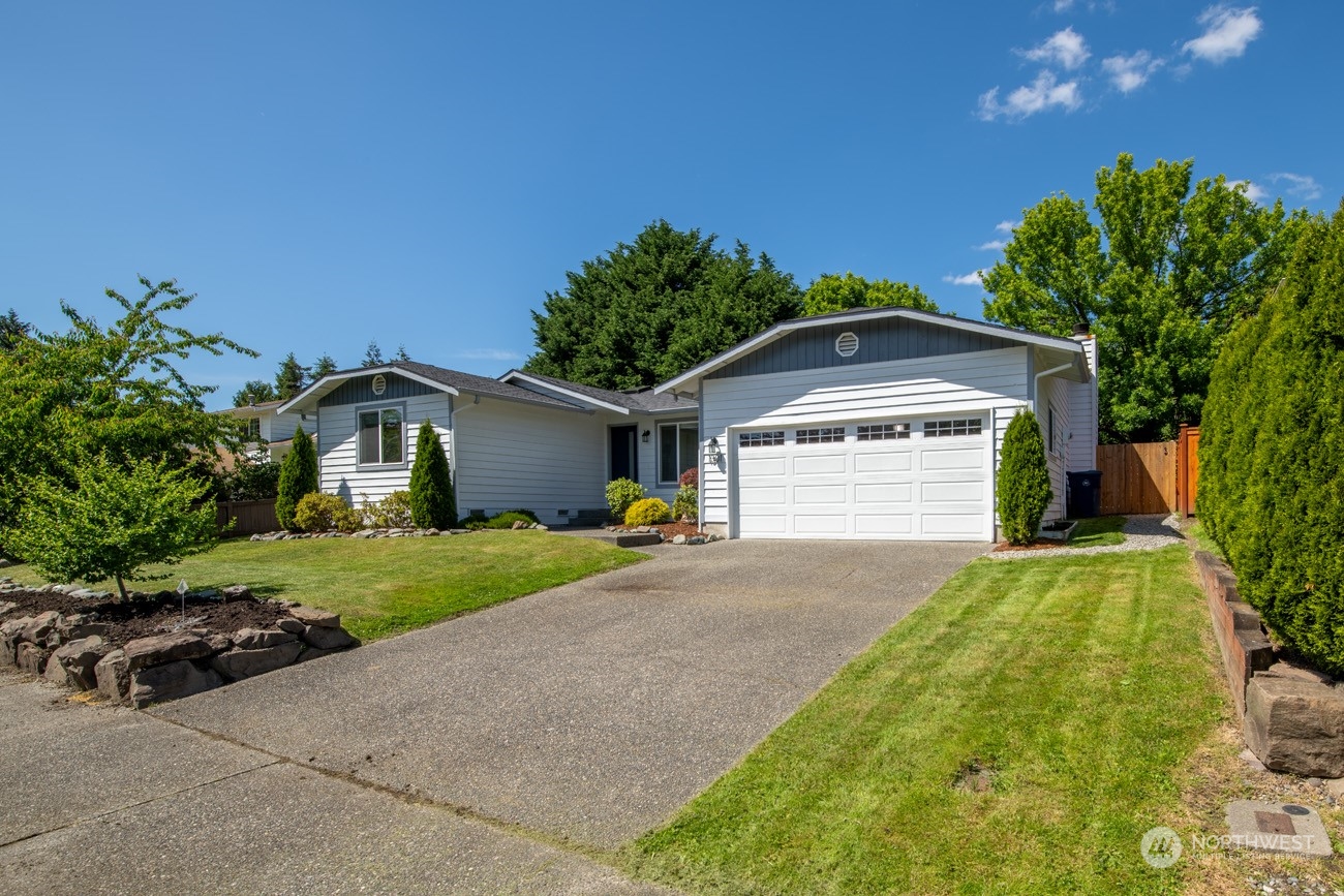 1301 234th Street Southwest Bothell, WA 98021 - Photo 2 of 21 a front view of a house with a yard and garage