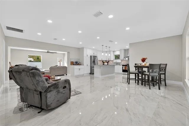 a living room with furniture and a dining table with kitchen view