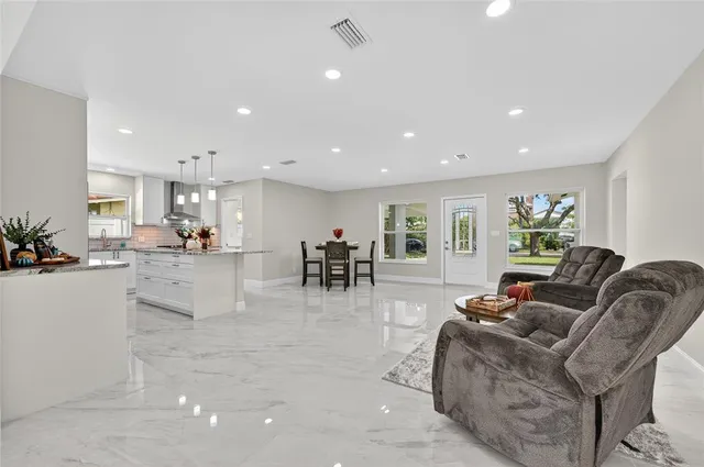a living room with furniture and a dining table with kitchen view