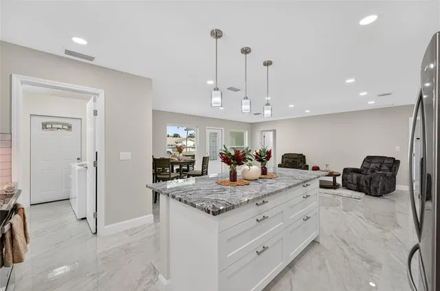 a view of living room kitchen and chandelier