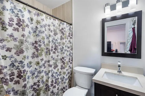 a bed sitting in a bedroom next to a window with pc on the table