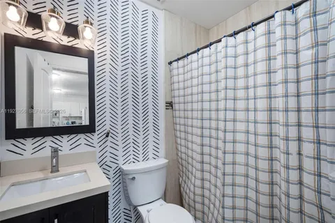 a white toilet sitting next to a bathroom sink