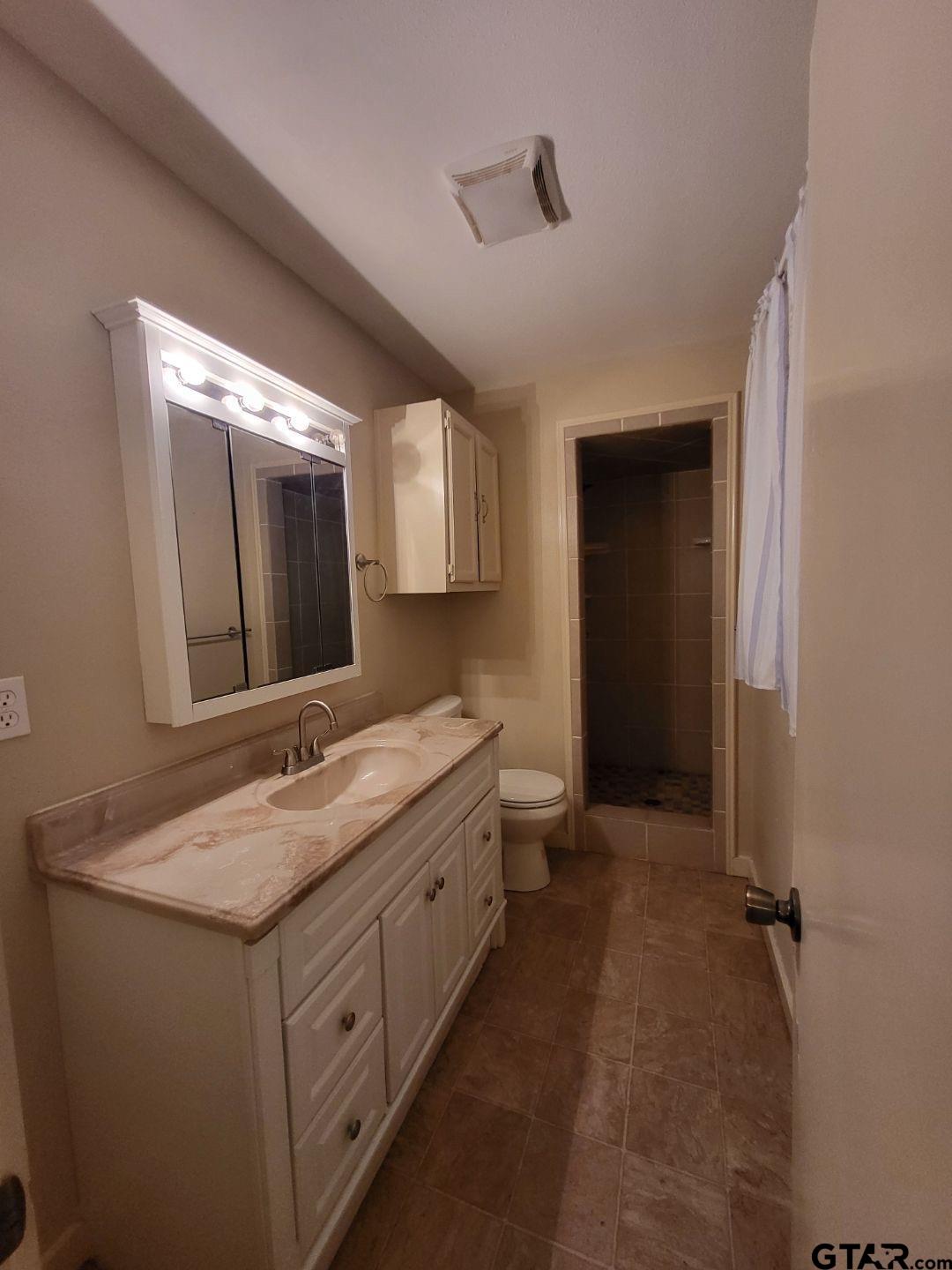 600 Cypress Street Pittsburg, TX 75686 - Photo 12 of 31 a bathroom with a granite countertop sink mirror and double