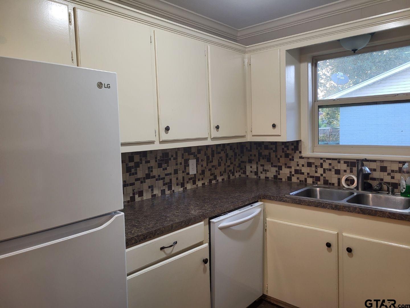600 Cypress Street Pittsburg, TX 75686 - Photo 22 of 31 a kitchen with white cabinets and white appliances
