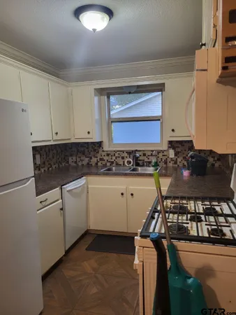 a kitchen with a stove and white cabinets