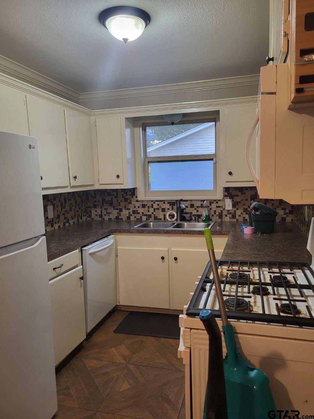 600 Cypress Street Pittsburg, TX 75686 - Photo 25 of 31 a kitchen with a stove and white cabinets