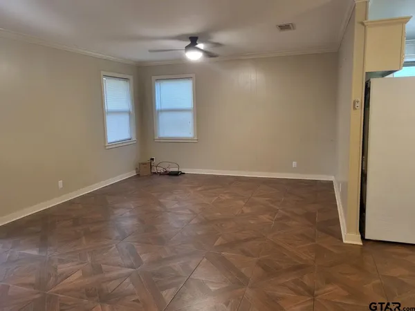 en empty room with windows and a ceiling fan