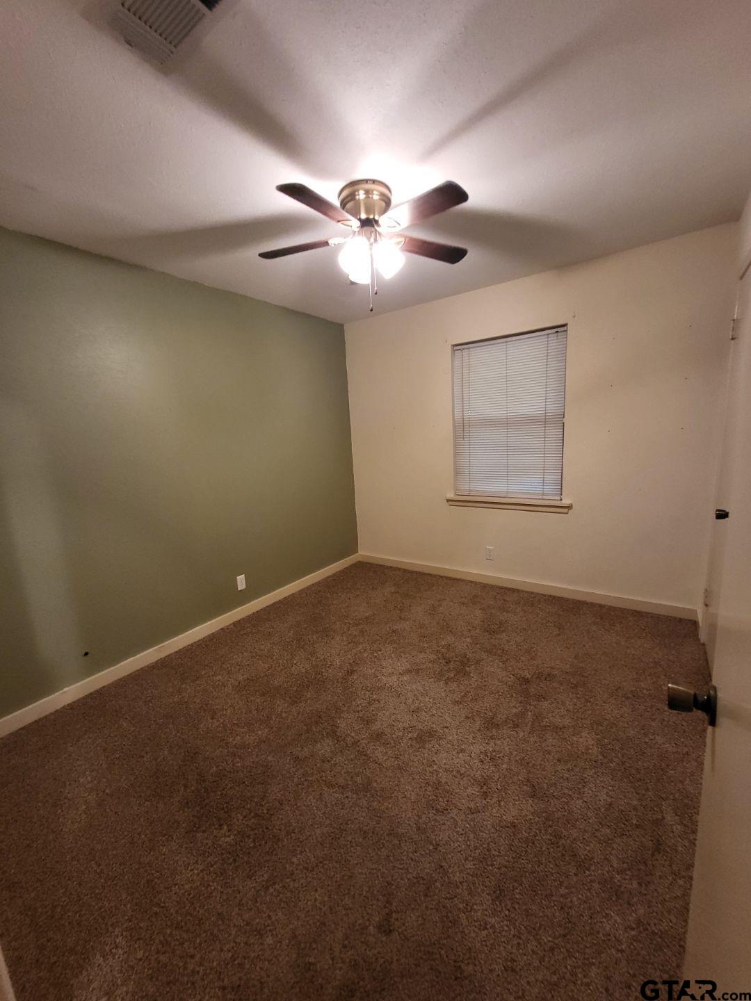 600 Cypress Street Pittsburg, TX 75686 - Photo 7 of 31 an empty room with windows and fan
