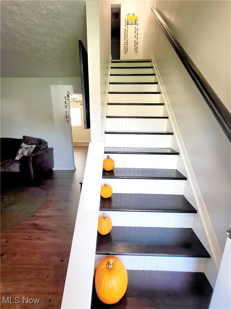 631 Root Road Lorain, OH 44052 - Photo 18 of 24 Stairs featuring a textured ceiling and hardwood / wood-style floors