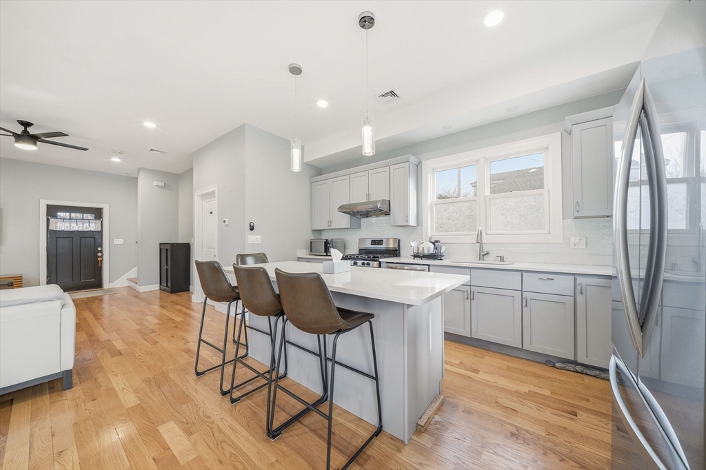 5 Main Street Quincy, MA 02169 - Photo 14 of 42 a kitchen with stainless steel appliances granite countertop a refrigerator a sink dishwasher and white cabinets with wooden floor