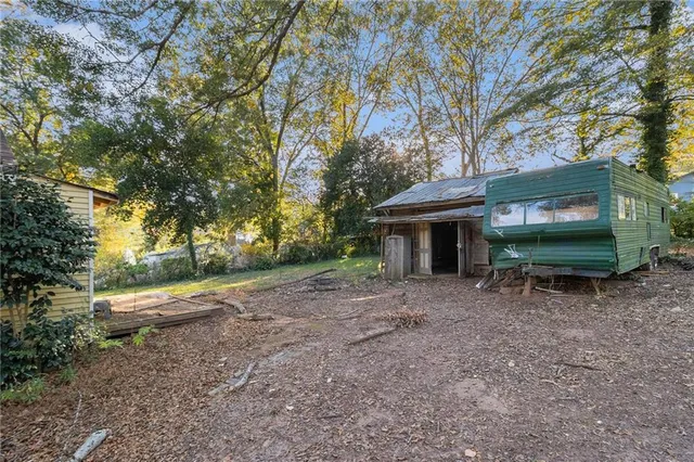 a view of a house with a yard and large tree