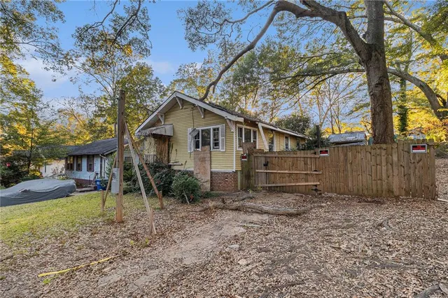 a view of backyard of house with wooden fence