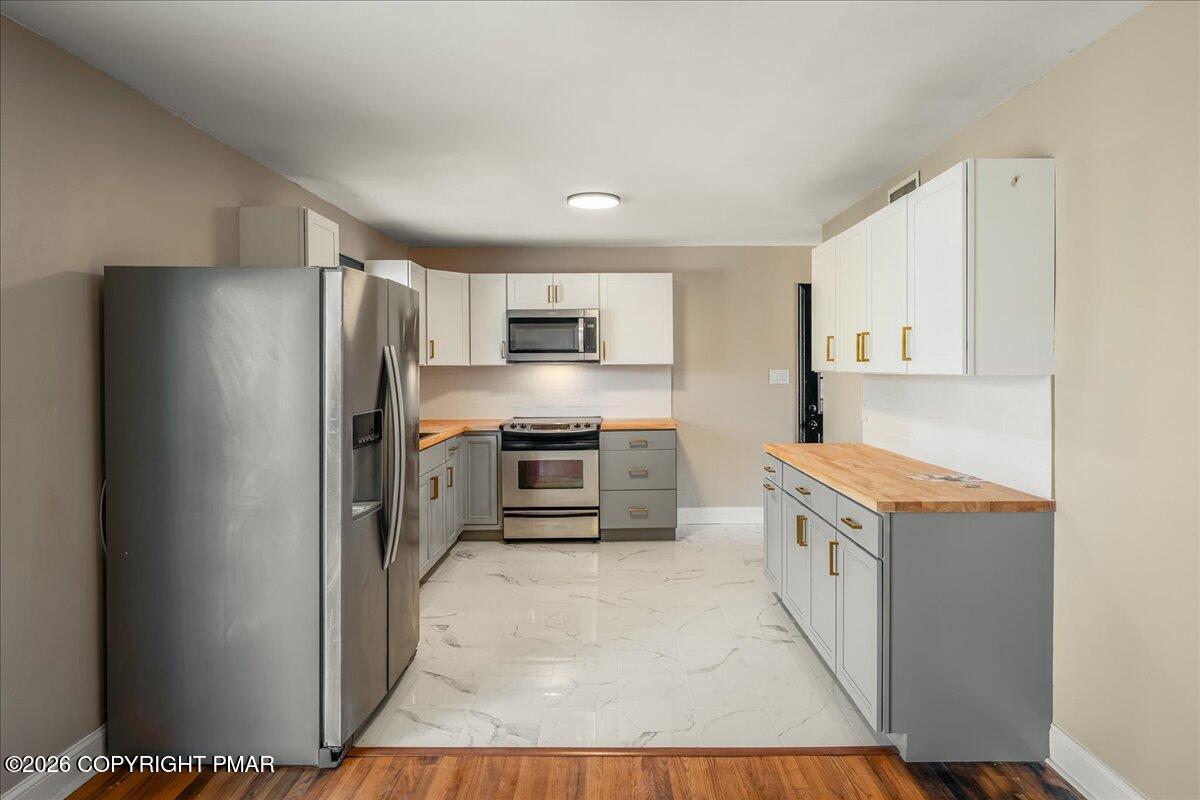 7136 Howell Terrace Stroudsburg, PA 18360 - Photo 8 of 35 a kitchen with stainless steel appliances a stove refrigerator and a refrigerator
