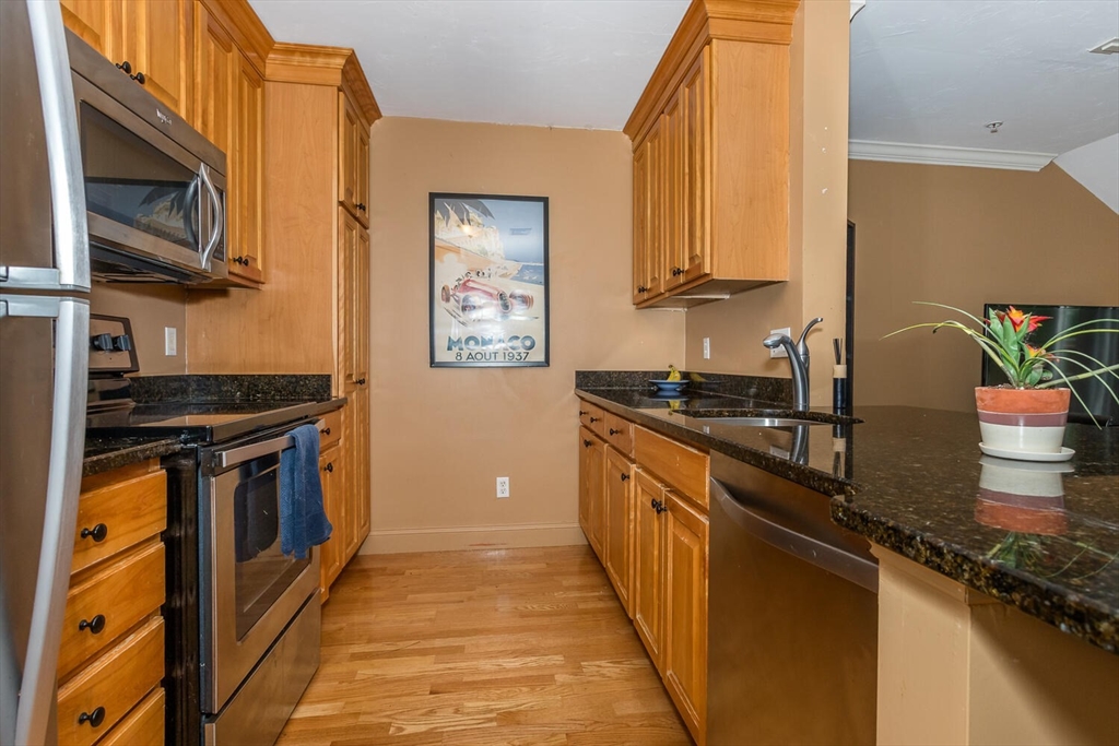 4 Forge Pond, Unit E Canton, MA 02021 - Photo 8 of 15 a kitchen with stainless steel appliances granite countertop a stove a sink and a microwave