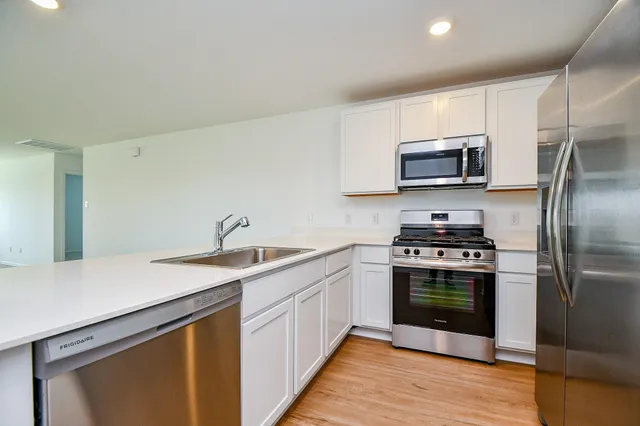 a kitchen with stainless steel appliances a stove microwave and refrigerator