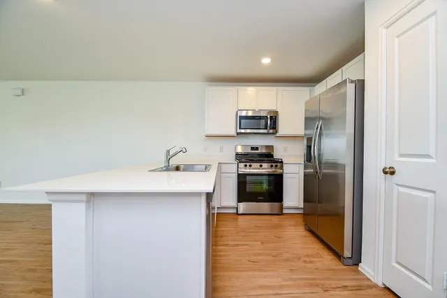 a kitchen with kitchen island a sink stainless steel appliances and refrigerator