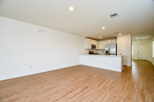 a view of kitchen with refrigerator and wooden floor