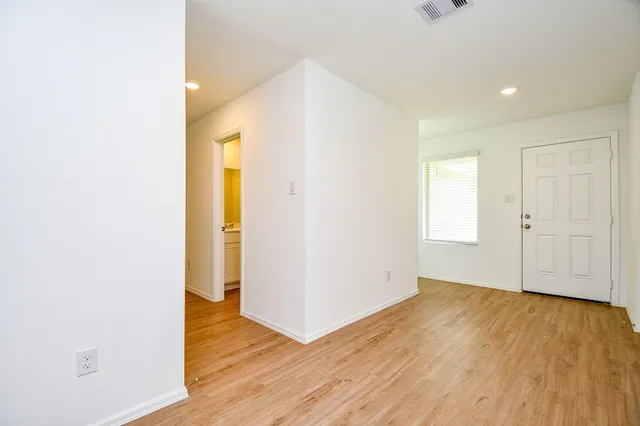 a view of an empty room with wooden floor
