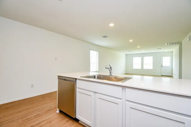 a kitchen with a sink cabinets and wooden floor