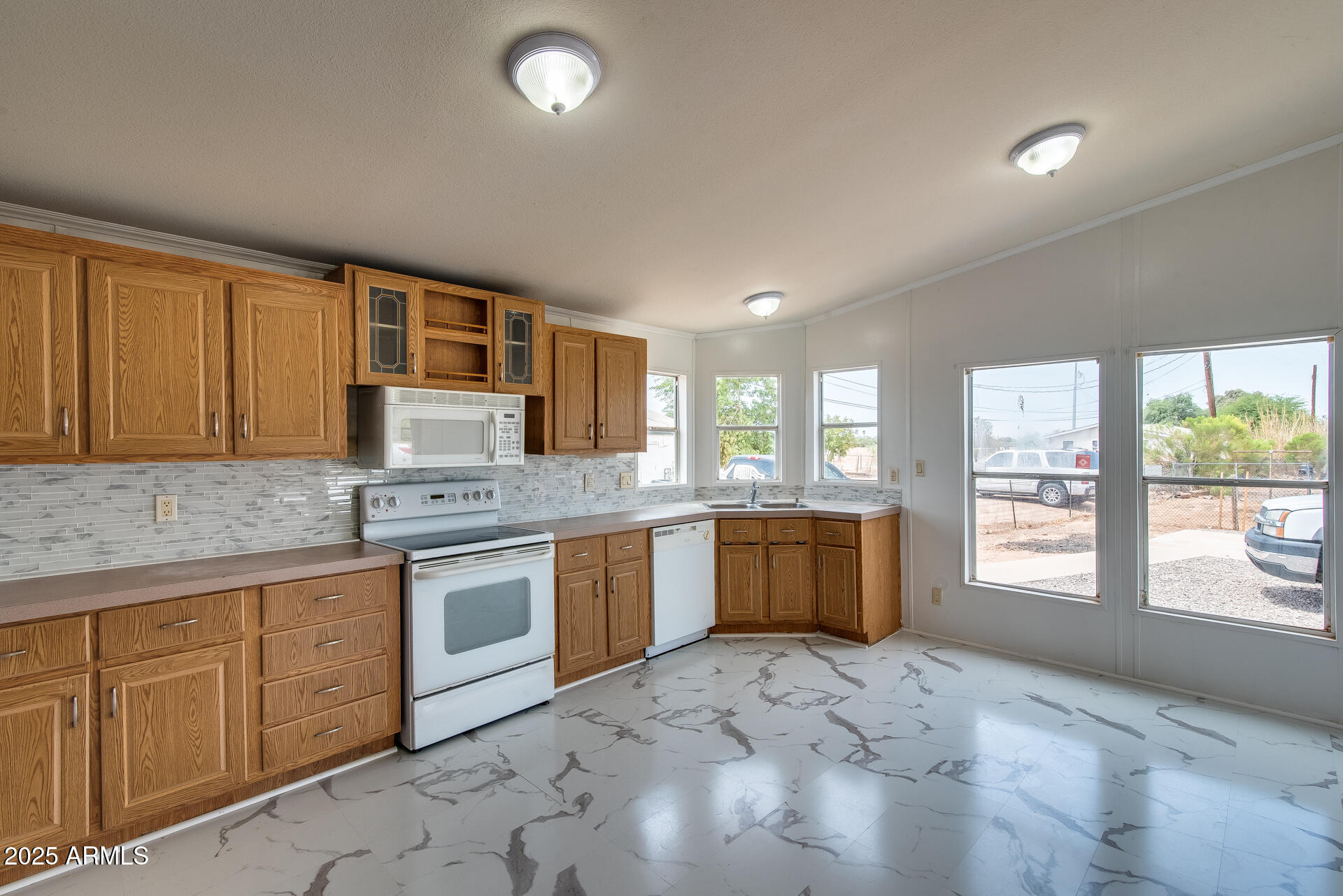 a kitchen with stainless steel appliances granite countertop a stove a sink and a refrigerator with wooden cabinets