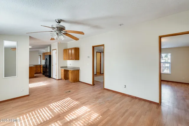 a view of an empty room with wooden floor and closet