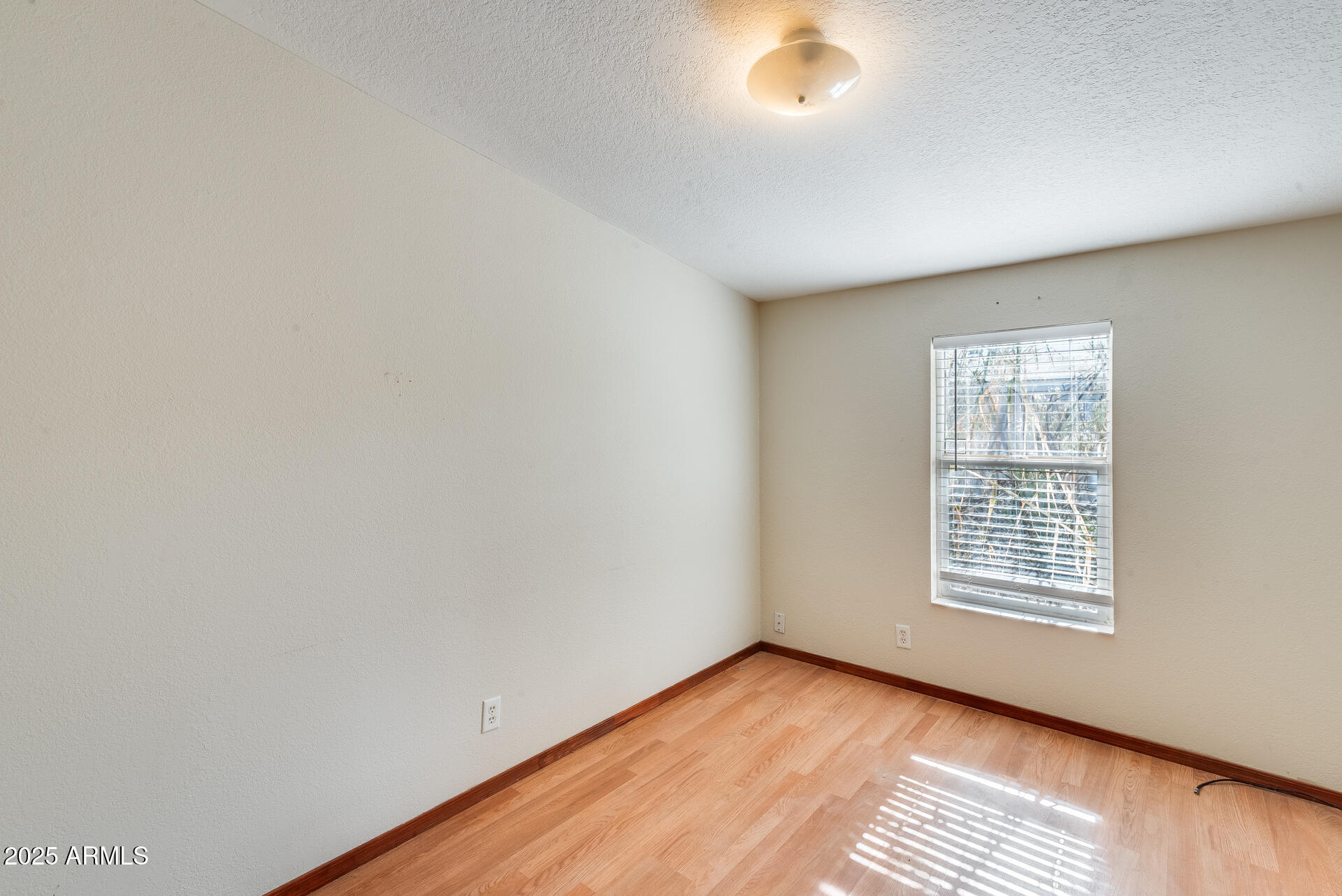 1047 South Main Street Coolidge, AZ 85128 - Photo 29 of 72 a view of an empty room with wooden floor and a window