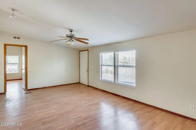 a large kitchen with stainless steel appliances granite countertop a large window and a wooden floor