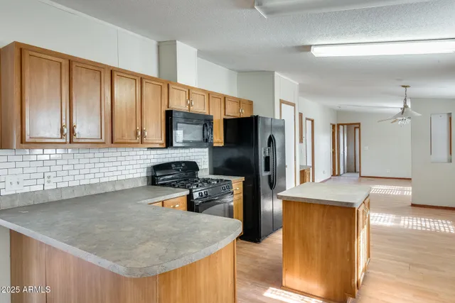 a kitchen with stainless steel appliances granite countertop a sink a stove top oven a counter space and cabinets