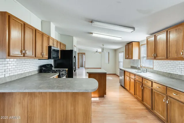 a kitchen that has a sink a stove counter top space and cabinets