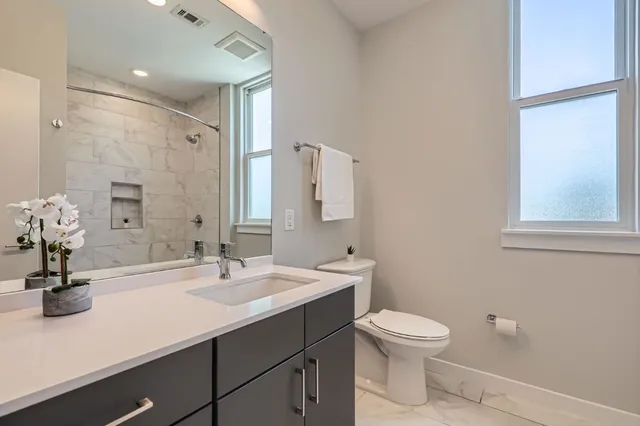 a bathroom with a sink a toilet and a mirror