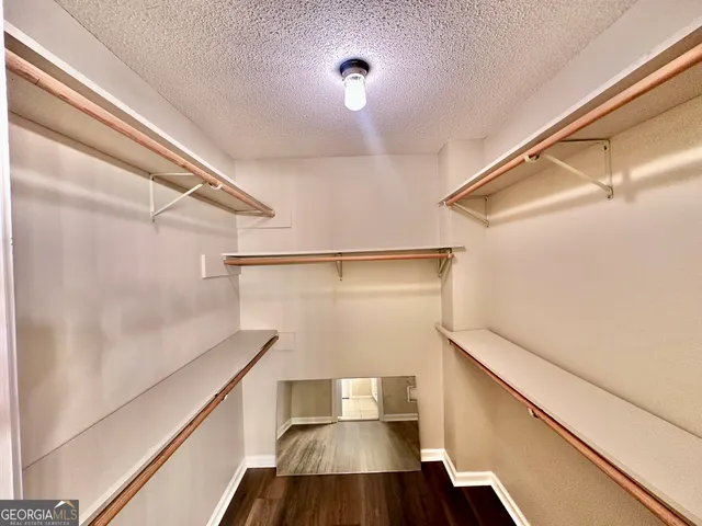 a view of empty room with wooden floor and ceiling fan