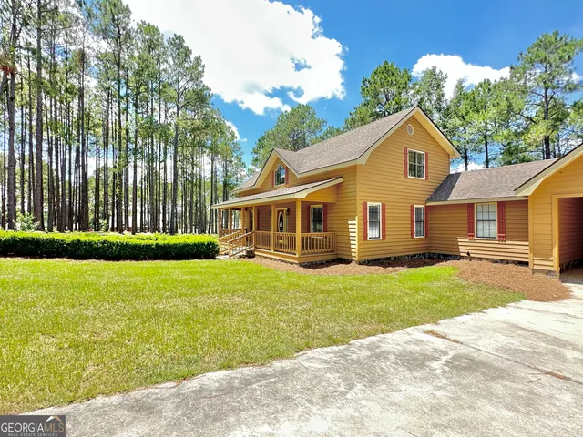 a view of a yard in front of a house with a large tree
