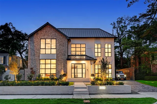 a front view of a house with a garden and tree