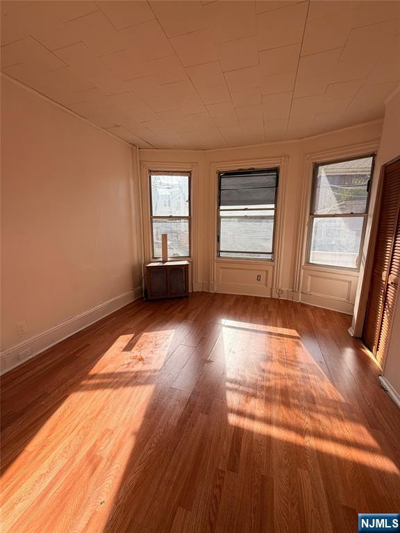 113 Martin Street, Unit 1 Paterson, NJ 07501 - Photo 1 of 14 an empty room with wooden floor and windows
